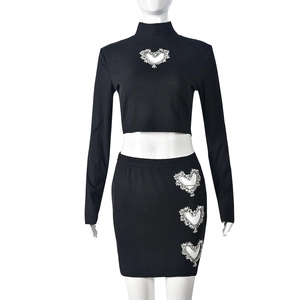 Close-up of heart-shaped cutout with silver rhinestones on ribbed knit fabric