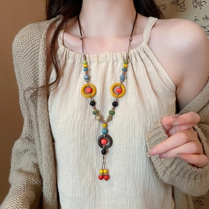 Detailed shot of ethnic ceramic bead necklace with colorful tassels on a model