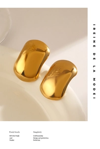 Macro detail of hand-polished geometric earrings with warm golden mirror finish