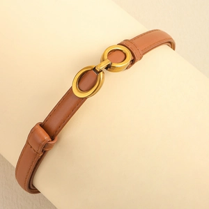 Gros plan d'une ceinture en cuir marron avec boucle mors dorée sur un support