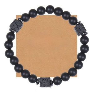Detail of matte black stone bead bracelet with lava rocks on kraft paper gift card