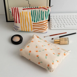 Detail of floral corduroy makeup bags with metal zippers and soft texture
