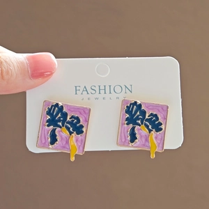 Detail of square alloy stud earrings with blue iris flower on purple ripple background