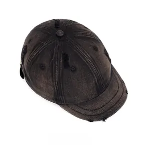 Detail view of washed dark grey canvas short brim cap with distressed edges and top button