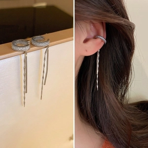 Détails et vue portée des boucles d'oreilles nœud argenté avec strass et double gland