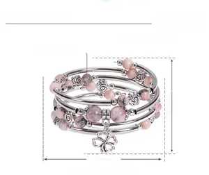 Macro view of multi-layer boho bracelet with 6mm pink zebra stone and clover charm