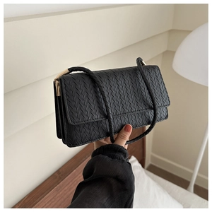 Detail of black woven rectangular shoulder bag featuring classic Intrecciato pattern and gold hardware