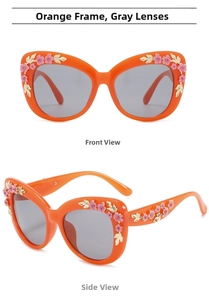 Detailed view of orange baroque sunglasses with 3D pink flowers and gold leaves accents