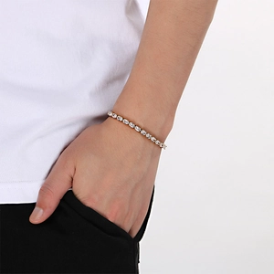 Gros plan d'un bracelet de tennis doré avec oxydes de zirconium sur le poignet