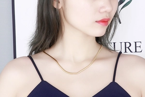 Gros plan d'un collier chaîne serpent dorée élégante sur un mannequin femme