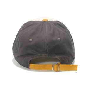 Detail of adjustable metal buckle and contrast yellow strap on cotton baseball cap