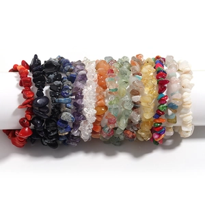 Primo piano dettaglio di vari bracciali con pietre grezze di cristallo naturale e agata.