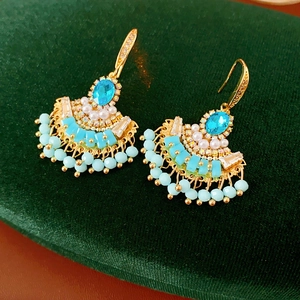Détail de boucles d'oreilles vintage avec pierres bleues et perles turquoise sur velours