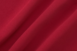 Vista macro dettagliata del tessuto rosso intenso che mostra la trama e la morbidezza del capo