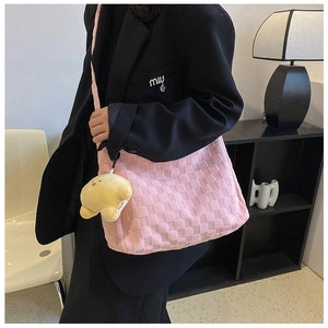 Pink woven tote bag featuring textured lattice pattern and yellow star plush charm