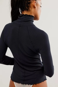 Rear view of slim fit dark waffle knit long sleeve top with ruffle trim details