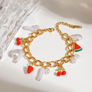 Detail of a fruit pearl bracelet with gold chain, cherry charms, and white pearls