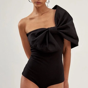 Détail du maillot de bain noir asymétrique orné d'un grand nœud décoratif structuré