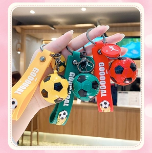 Dettaglio di portachiavi da calcio in PVC colorato giallo, verde e rosso con cinturini