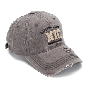 Close-up of NYC embroidery and distressed details on washed grey denim baseball cap