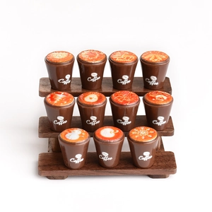 Miniature coffee cup models with snowflake latte art on a wooden tiered display stand