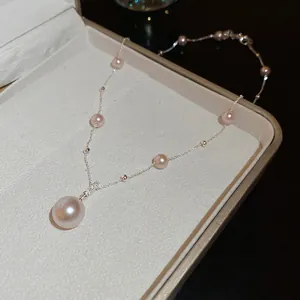 Elegant pale pink pearl pendant necklace with silver chain on white jewelry box display