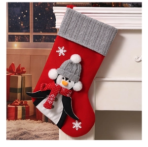 Detail of Christmas stocking featuring a 3D penguin hanging on a white fireplace mantel