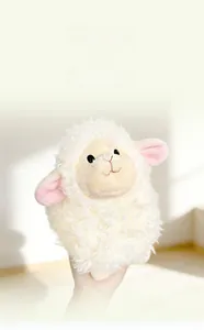 Close-up of soft plush texture and pink ear detail on white stuffed sheep doll