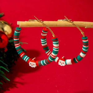 Detailed shot of Christmas hoop earrings with Santa charms on a festive background