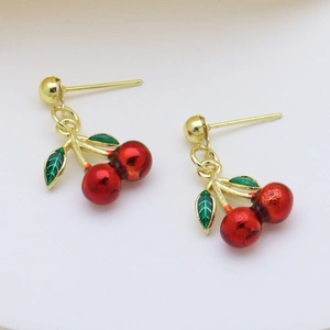 Chic gold cherry earrings with vibrant red glazed fruit and green enamel leaves on white