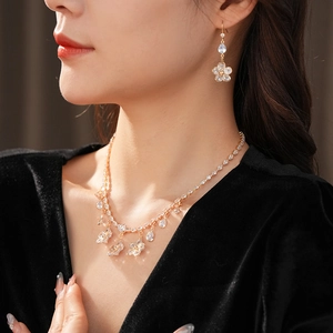 Elegant model wearing zircon flower and waterdrop pendant necklace with matching earrings