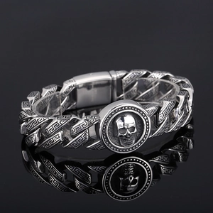 Detailed view of silver stainless steel skull bracelet with Greek fret pattern chain