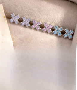 Detail of silver cross cartilage studs with zircon inlay and titanium screw flat back