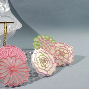 Detalle de colgantes de flores en resina DIY con acabado brillante y cadenas doradas