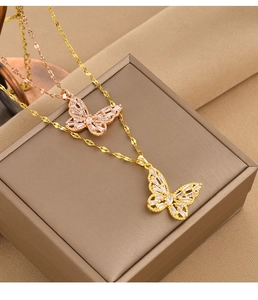 Detailed close-up of zircon-inlaid butterfly pendants in gold and rose gold titanium steel