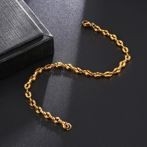 Macro shot of 4.5mm golden coffee bean link bracelet with lobster clasp on black background