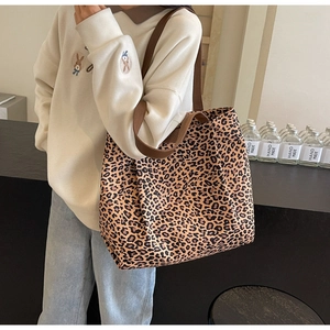 Grand sac fourre-tout en toile à motif léopard porté par un mannequin en tenue décontractée