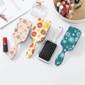 Set of 4 floral air cushion hairbrushes with colorful patterns on a white elegant vanity