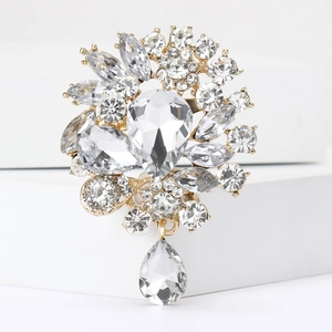 Close-up of luxury glass rhinestone brooch with pear-shaped drops on white steps