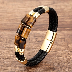 Detailed macro view of black braided leather bracelet with brown tiger eye stone and gold clasp