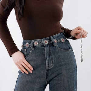 Detail of vintage silver waist chain featuring embossed discs and reddish-brown stones