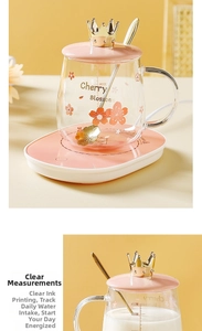 Close-up of pink cherry blossom glass mug showing 450ml capacity scale and golden spoon