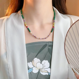 Detail of colorful beads with green malachite texture and natural pearls on necklace