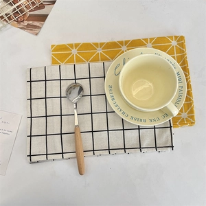 Linen placemats with geometric patterns and check design in a warm dining setting