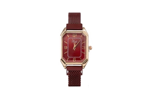 Detail of elegant gold square watch case with a deep red dial and mesh metal strap
