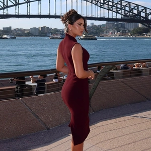 Gros plan d'une robe midi sans manches bordeaux avec coupe ajustée et détails élégants