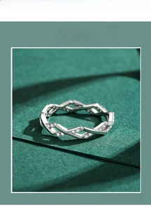 Macro view of geometric silver S925 ring with pavé-set stones on textured background