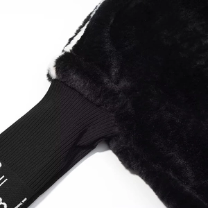 Detail of black faux fur jacket showing plush texture and white striped ribbed cuff