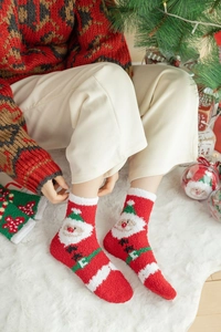 Détail de chaussettes de Noël douces en polaire corail avec motif Père Noël et texture