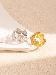 Detail of hollow butterfly pattern rings in gold and silver on stone pedestals